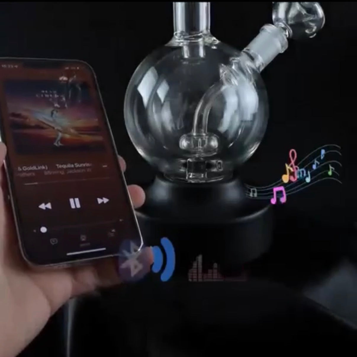 Glass water pipe with smartphone displaying music app and musical notes.